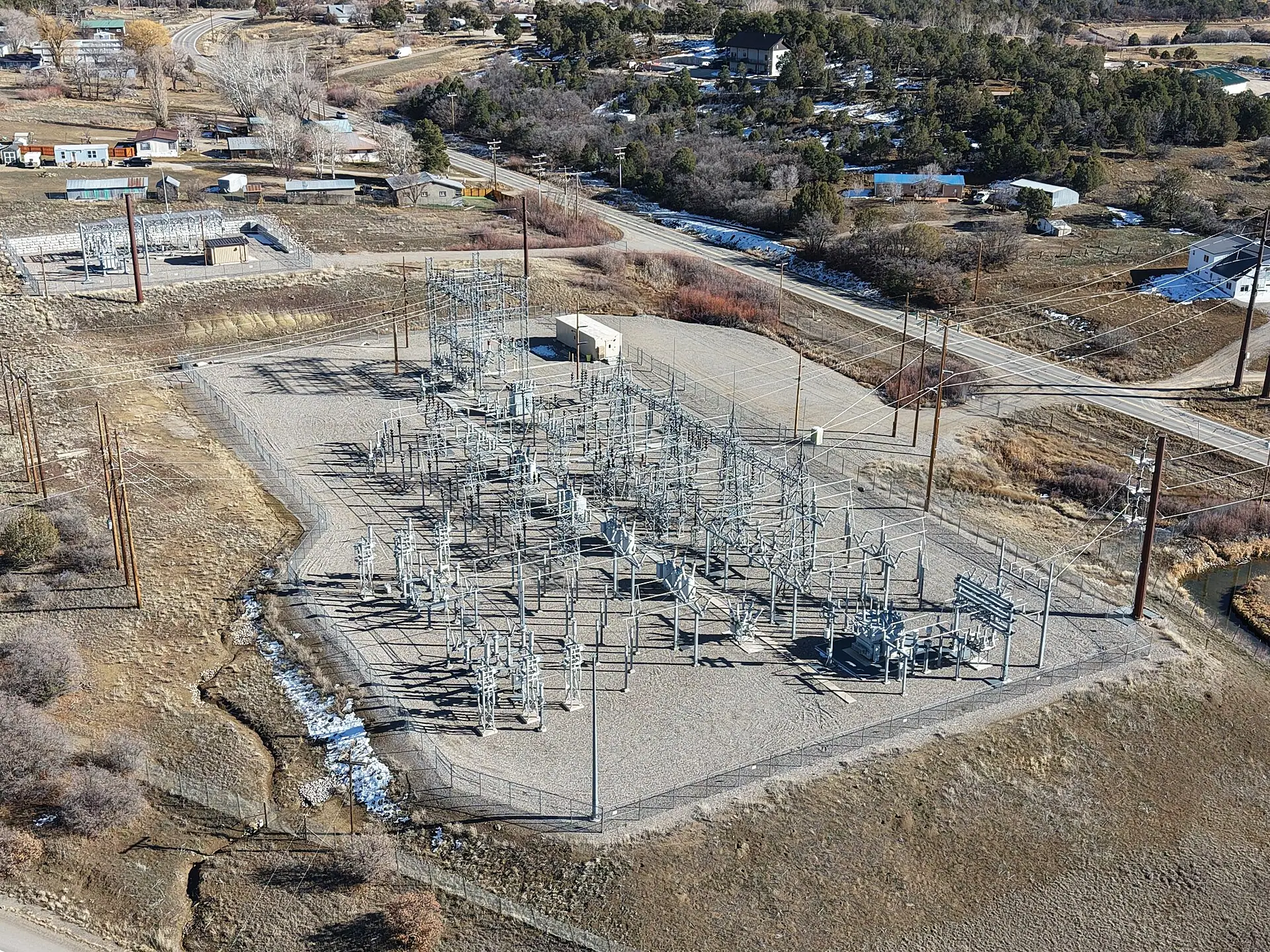 Aerial view of an electrical substation with overhead lines and switching equipment.
