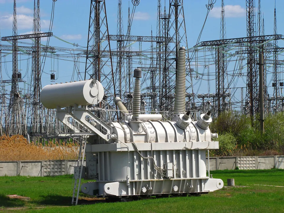 High-voltage transformer with insulating bushings in an electrical substation.
